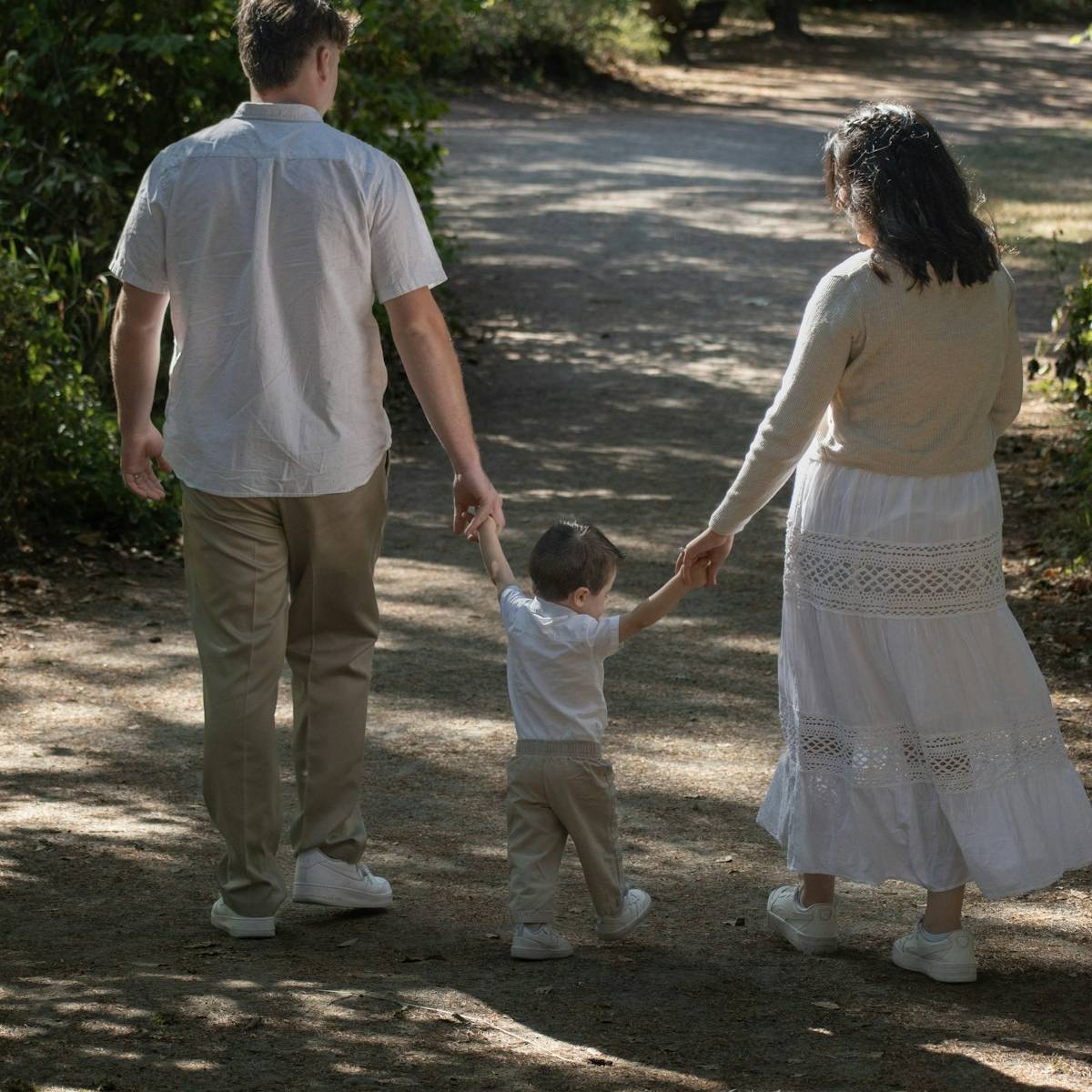 Family walking together on a shady woodland path